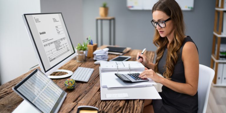 Accountant Calculating Tax At Desk